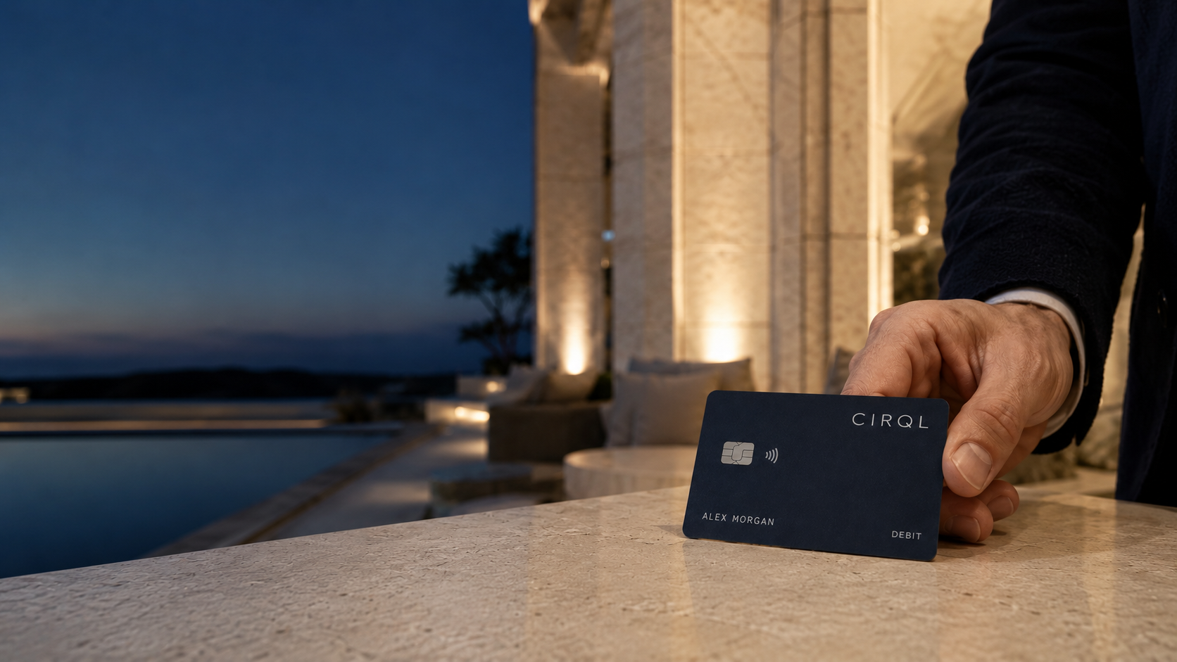 A realistic navy CIRQL card held in a refined stone hospitality setting
